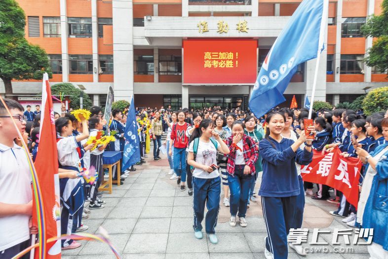 长沙市十一中,考生在学弟学妹们的祝福声中离开学校.